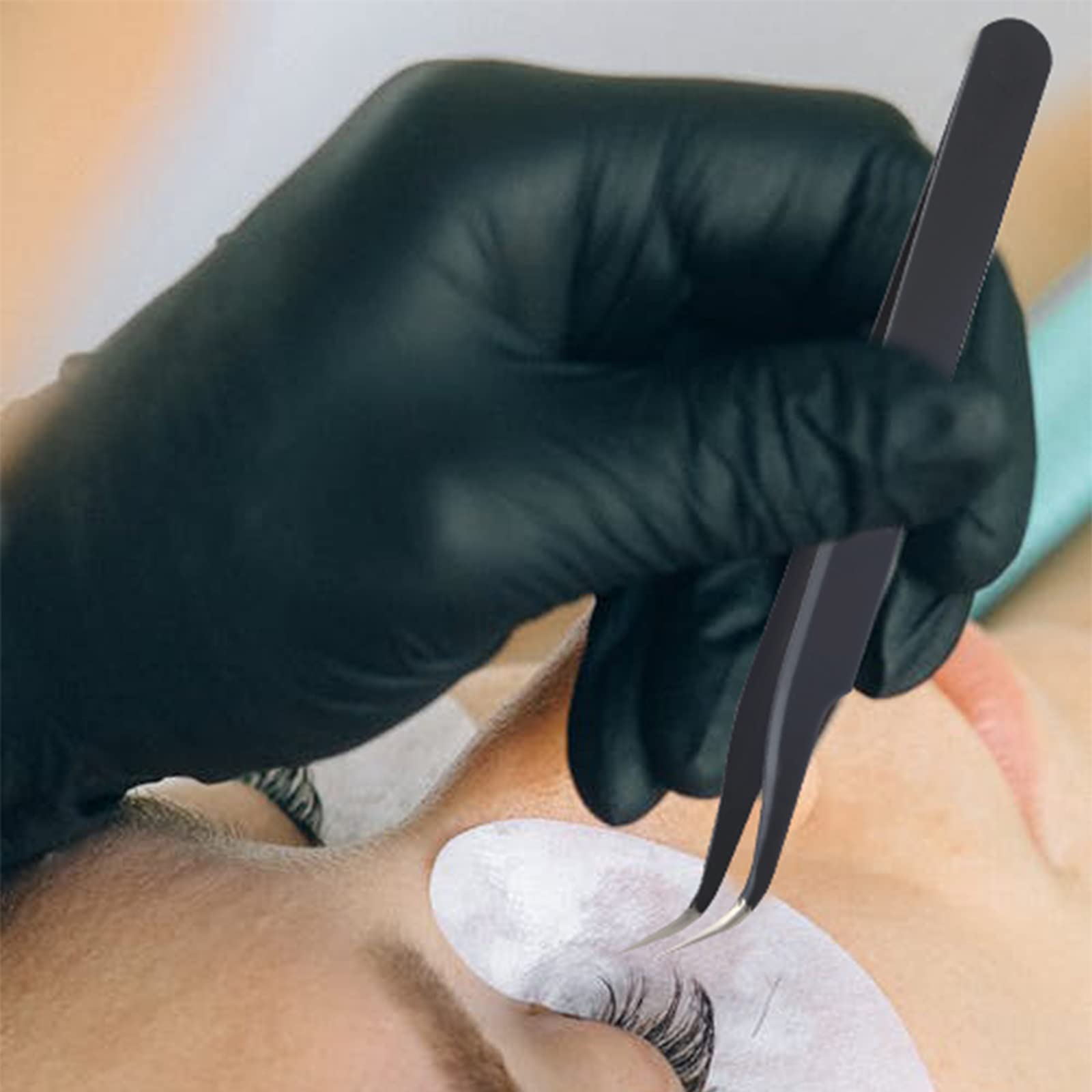 Eyelash extensions by eyelash extension artist using black tweezers