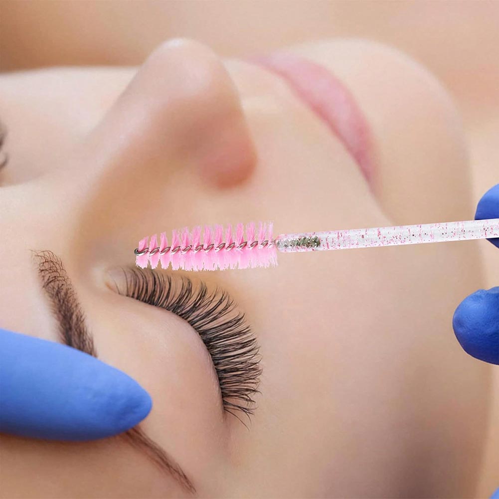 The eyelash artist uses an eyelash brush to clean the customer's eyelashes before extending them