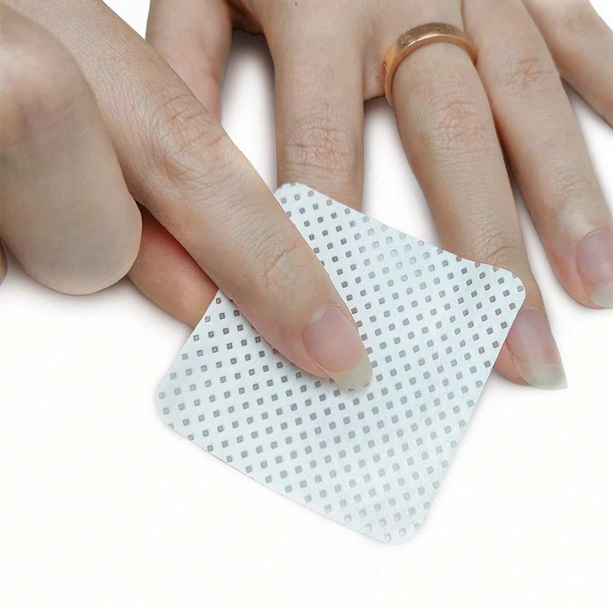 A woman is using nail wipes to wipe her nails